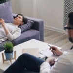 a man sitting on a couch next to a woman