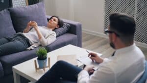 a man sitting on a couch next to a woman