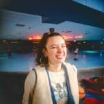 a woman standing in front of a skating rink