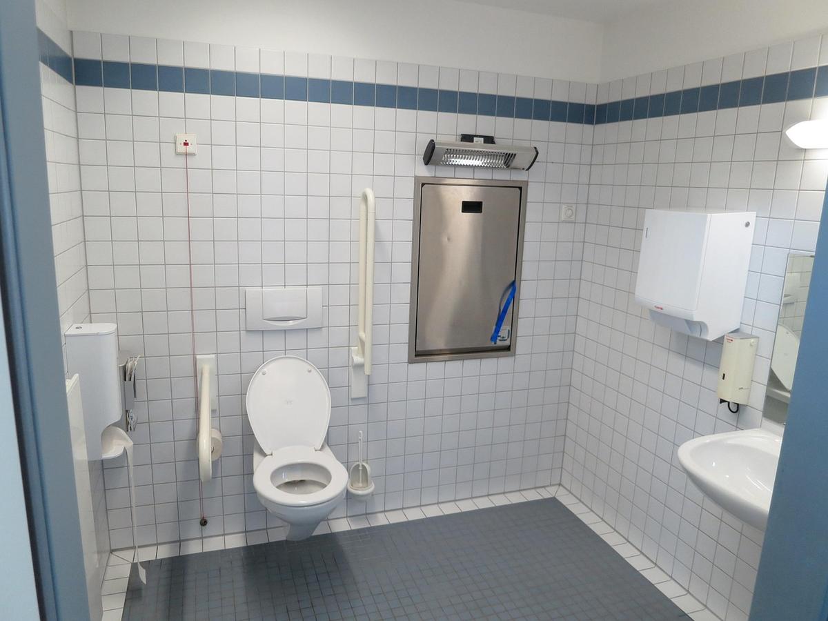 Salle de bains adaptée avec toilettes, lavabo, espace dégagé et équipements accessibles