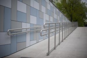 Rampe d'accès en métal le long d'une façade moderne en carrelage gris clair