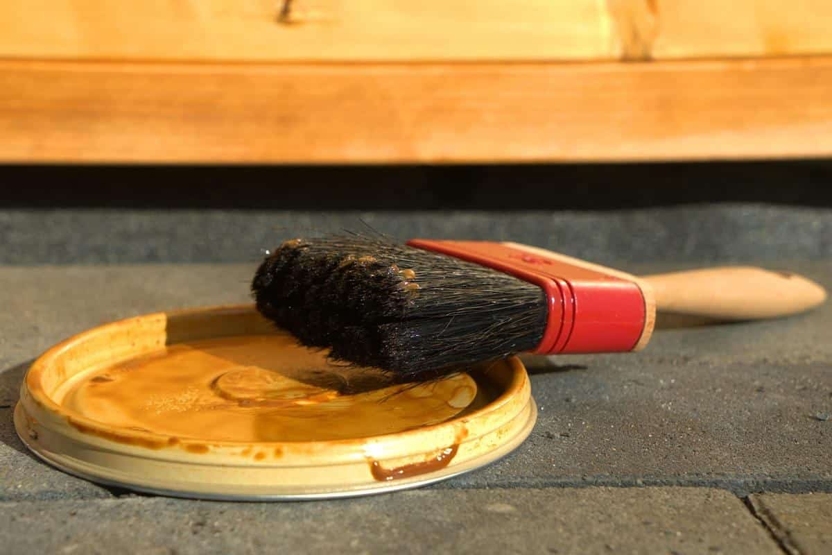 Un pinceau reposant sur un couvercle de pot de peinture