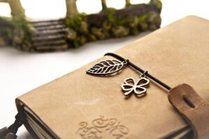 Livre en cuir avec bretelle et deux breloques métalliques