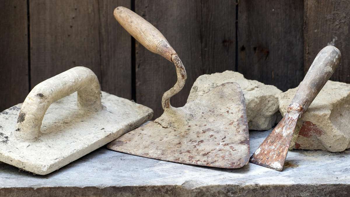 Des outils de maçonnerie en plâtre sur une surface de béton